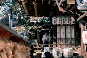 Tranquil scene at a Kyoto shrine with traditional lanterns and visitors exploring the site.